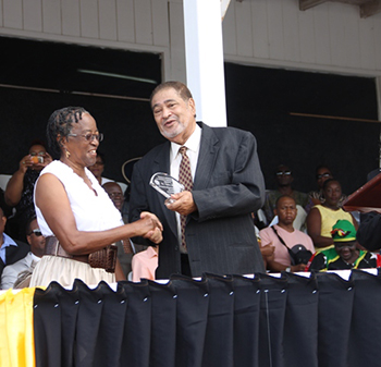 Hyleta Liburd receives an award from His Honour Eustace John Deputy Governor General for services in Education
